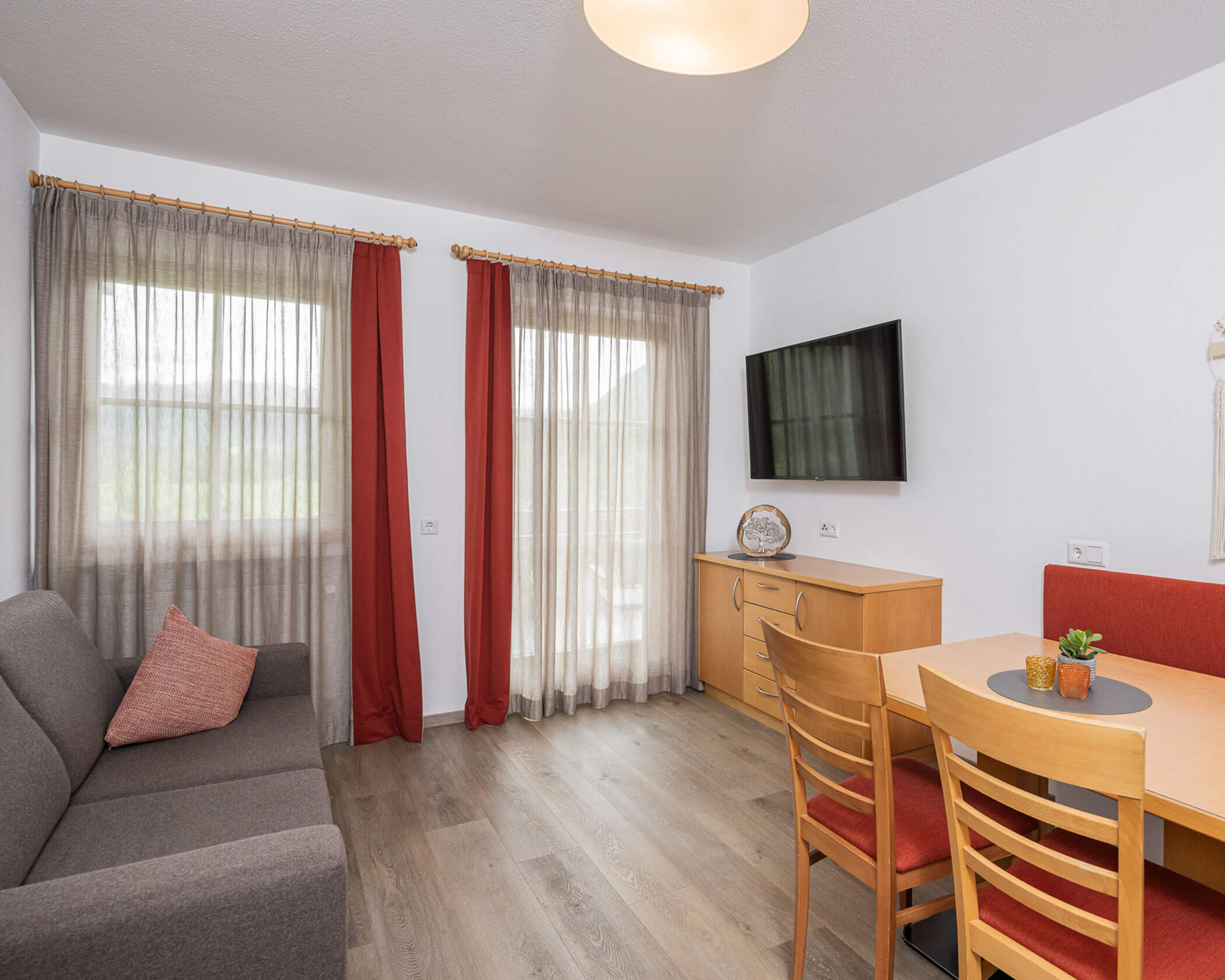 Wohn-Essbereich mit Sofa, TV und Esstisch im Apartment Typ B - Hotel Anewandter