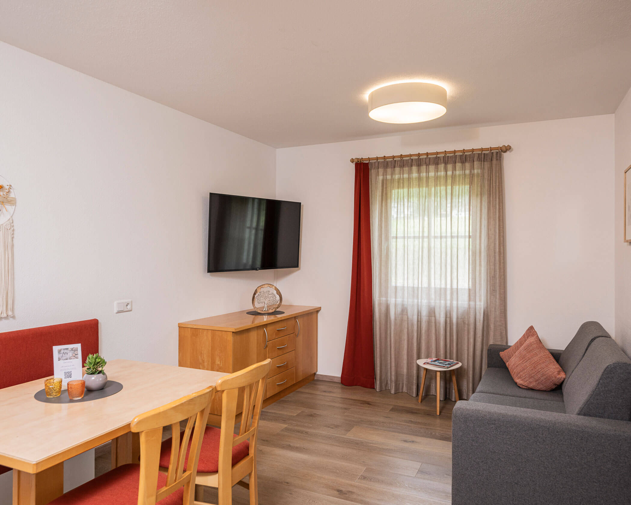 Wohn-Essbereich mit Esstisch, Sofa und TV im Apartment Typ C - Hotel Anewandter