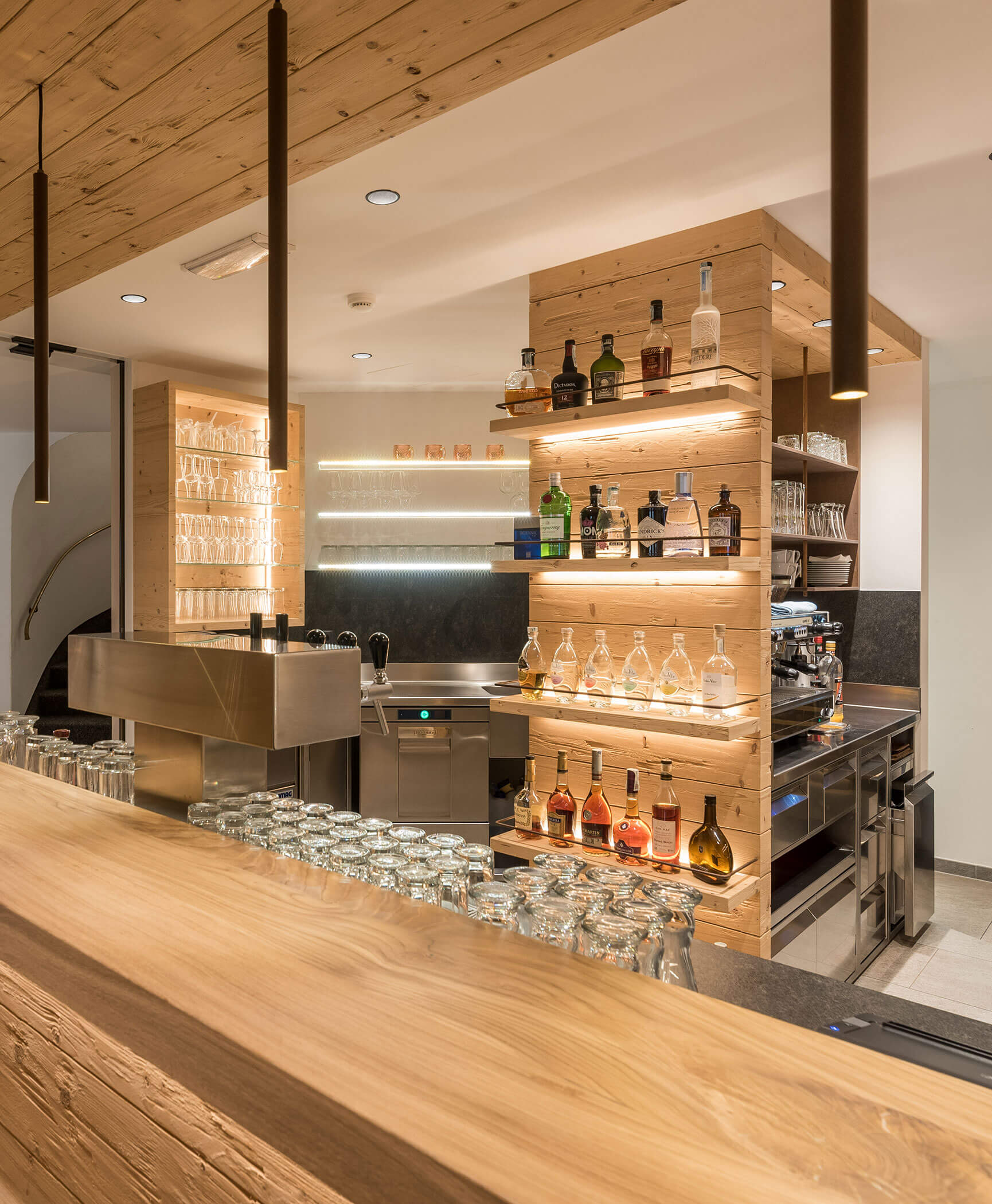 Il bar dell'hotel con macchina del caffè e diverse bottiglie - Hotel Anewandter