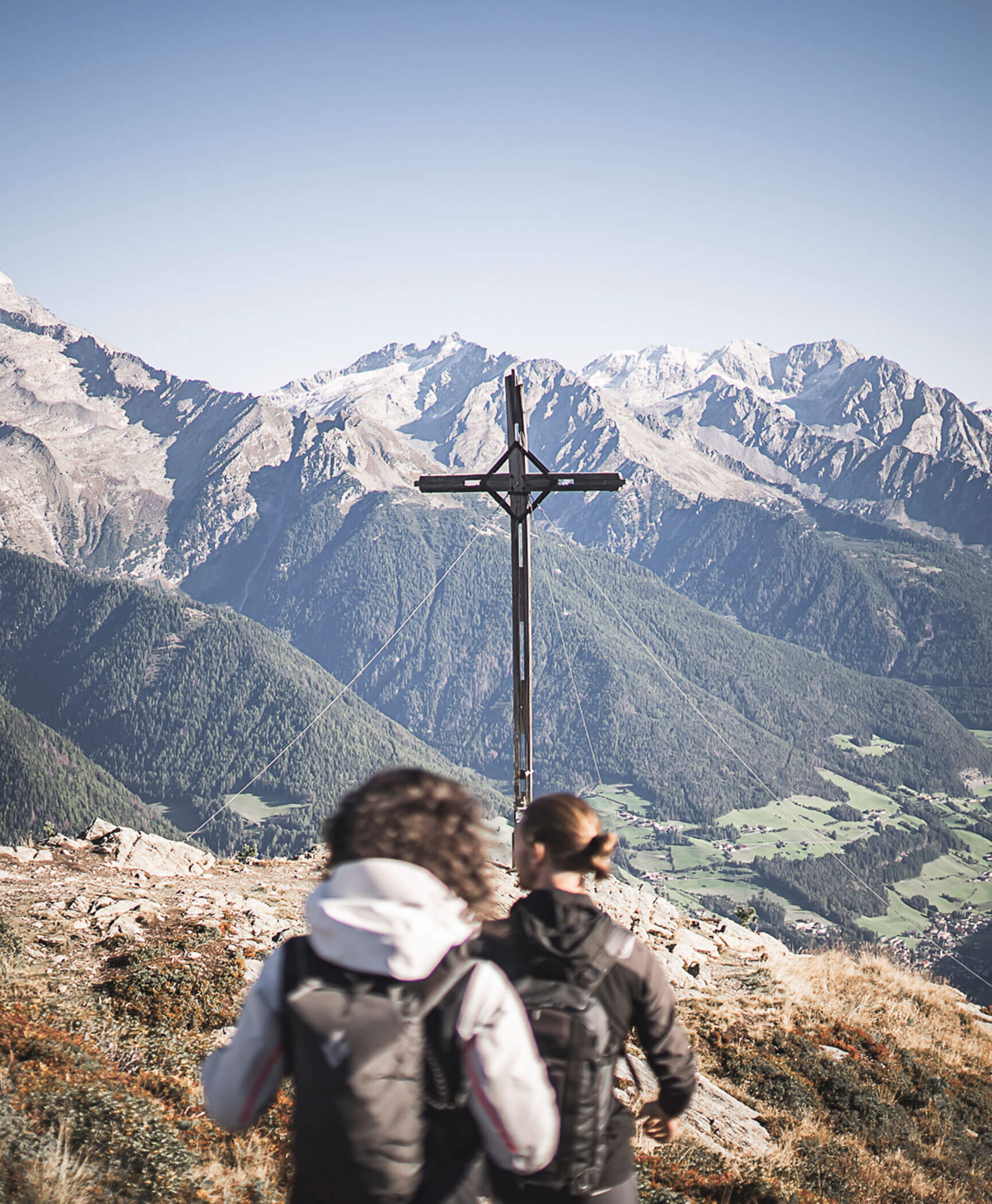 Two women in front of the Nockspitze cross in summer - Hotel Anewandter