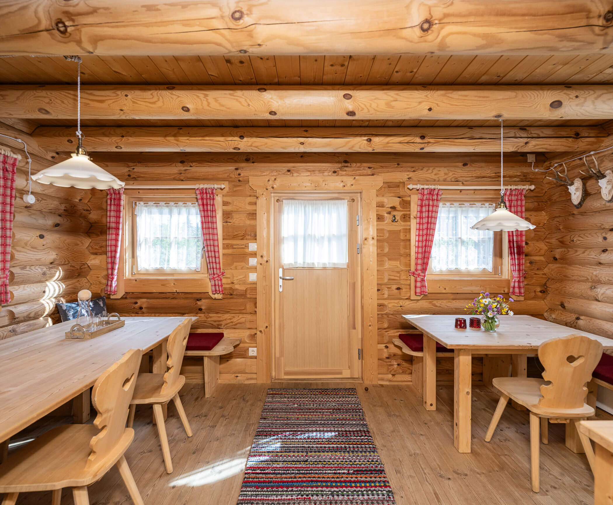 Aufenthaltsraum mit Tischen und Stühlen im Blockhaus - Hotel Anewandter