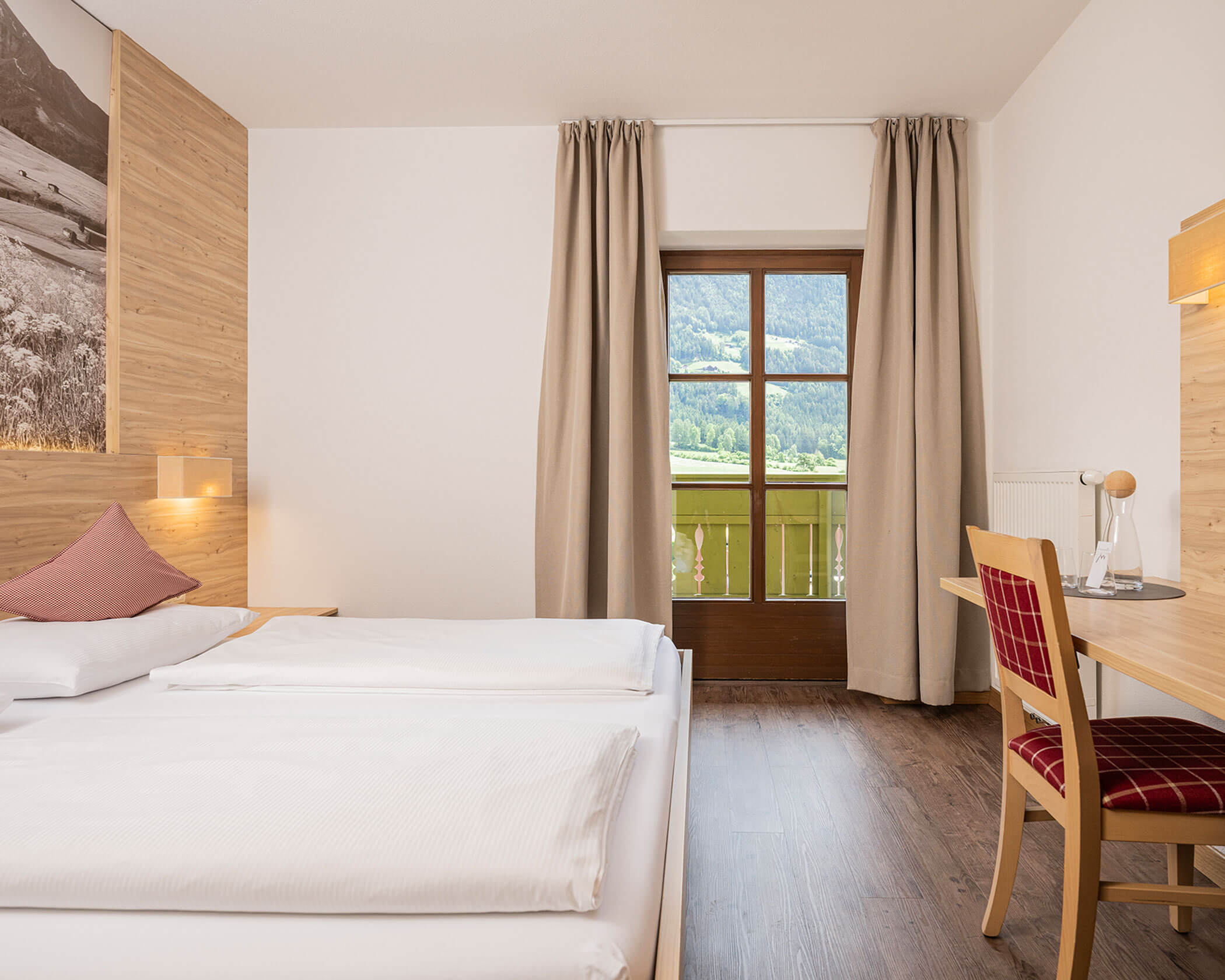 Letto matrimoniale con sedia e scrivania accanto nella camera doppia - Hotel Anewandter