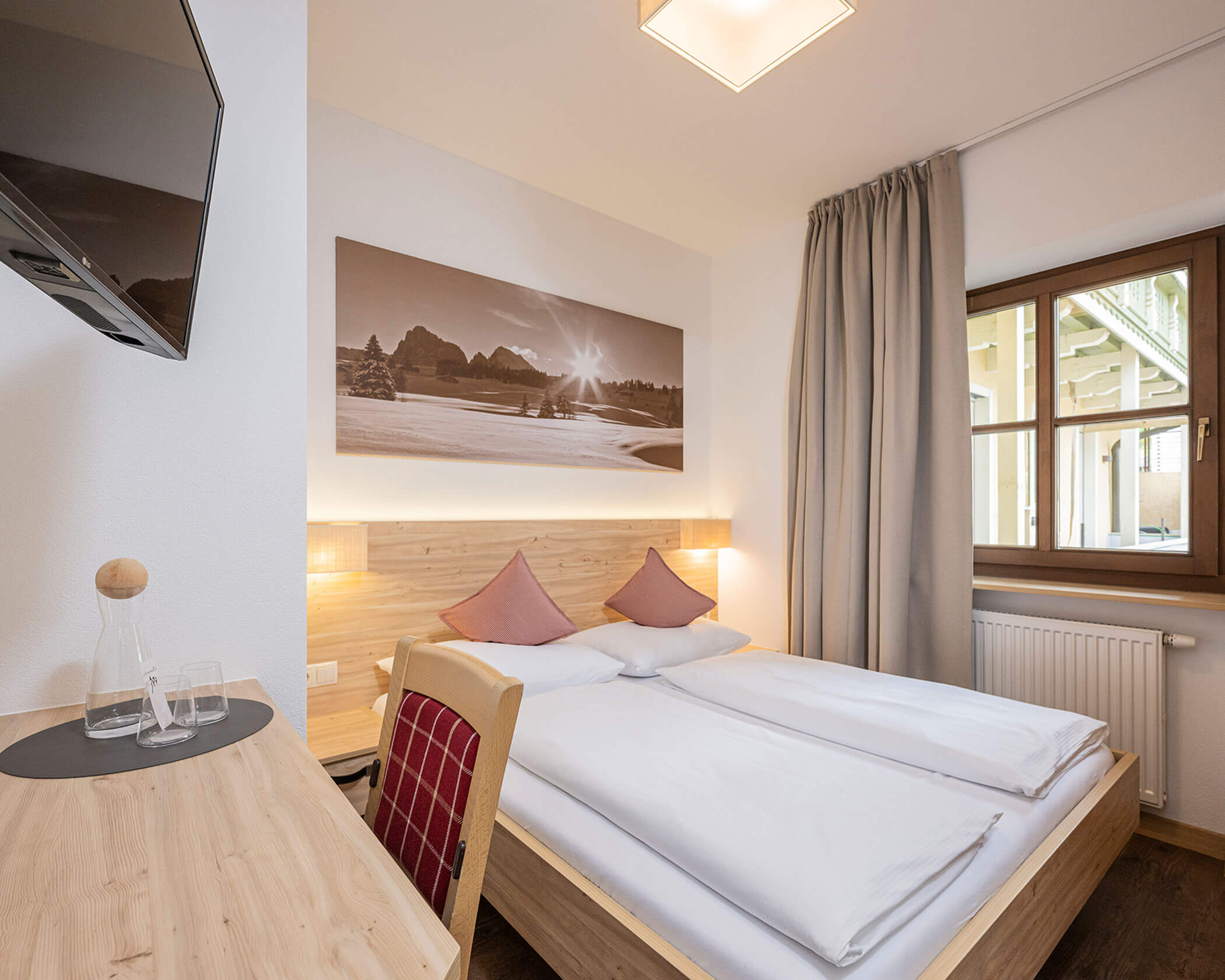 Camera da letto con letto matrimoniale, scrivania e TV nella camera familiare - Hotel Anewandter