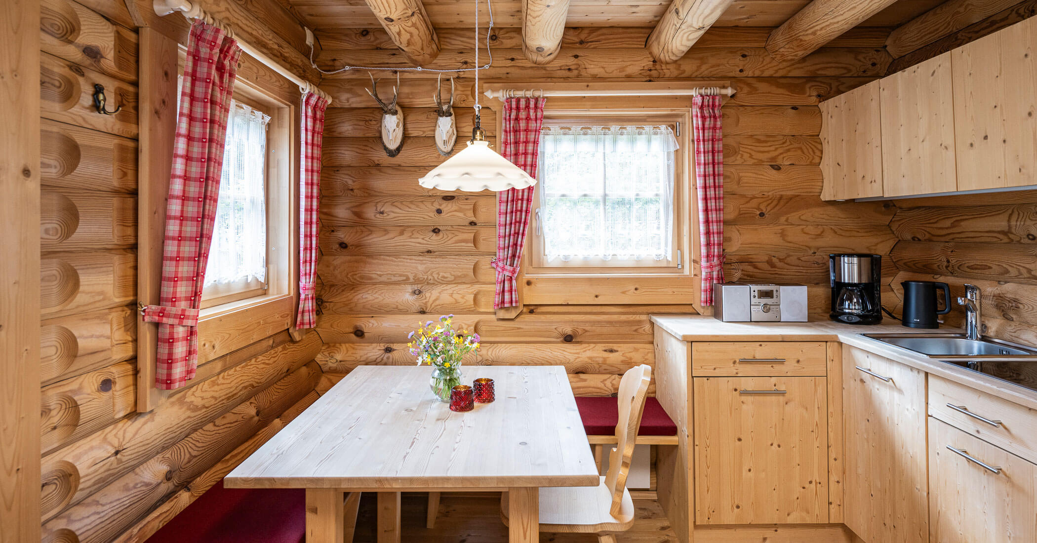Cucina con tavolo da pranzo nella casa in legno - Hotel Anewandter