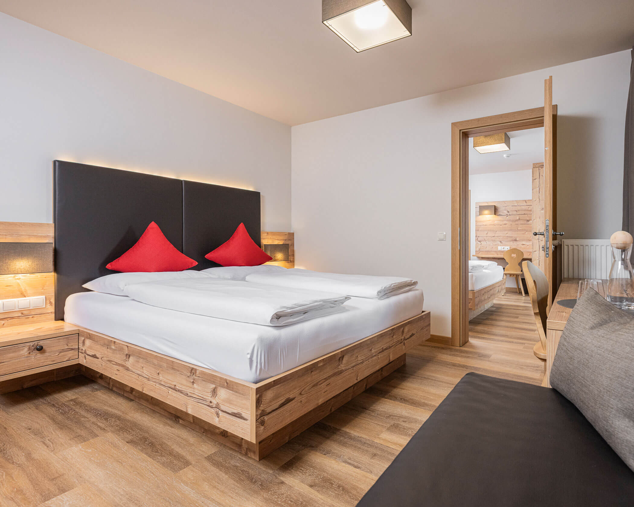 Letto matrimoniale con un divano davanti nella suite familiare - Hotel Anewandter