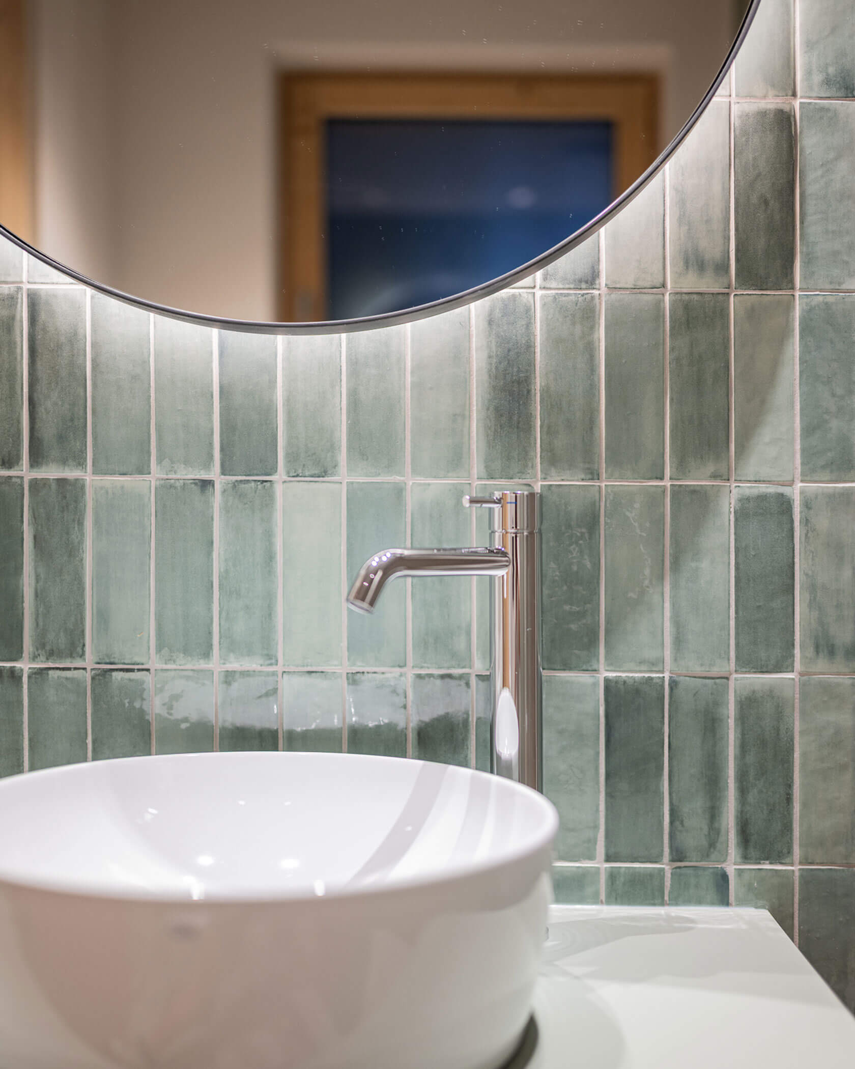 Badezimmer mit rundem Spiegel und Waschbecken - Hotel Anewandter