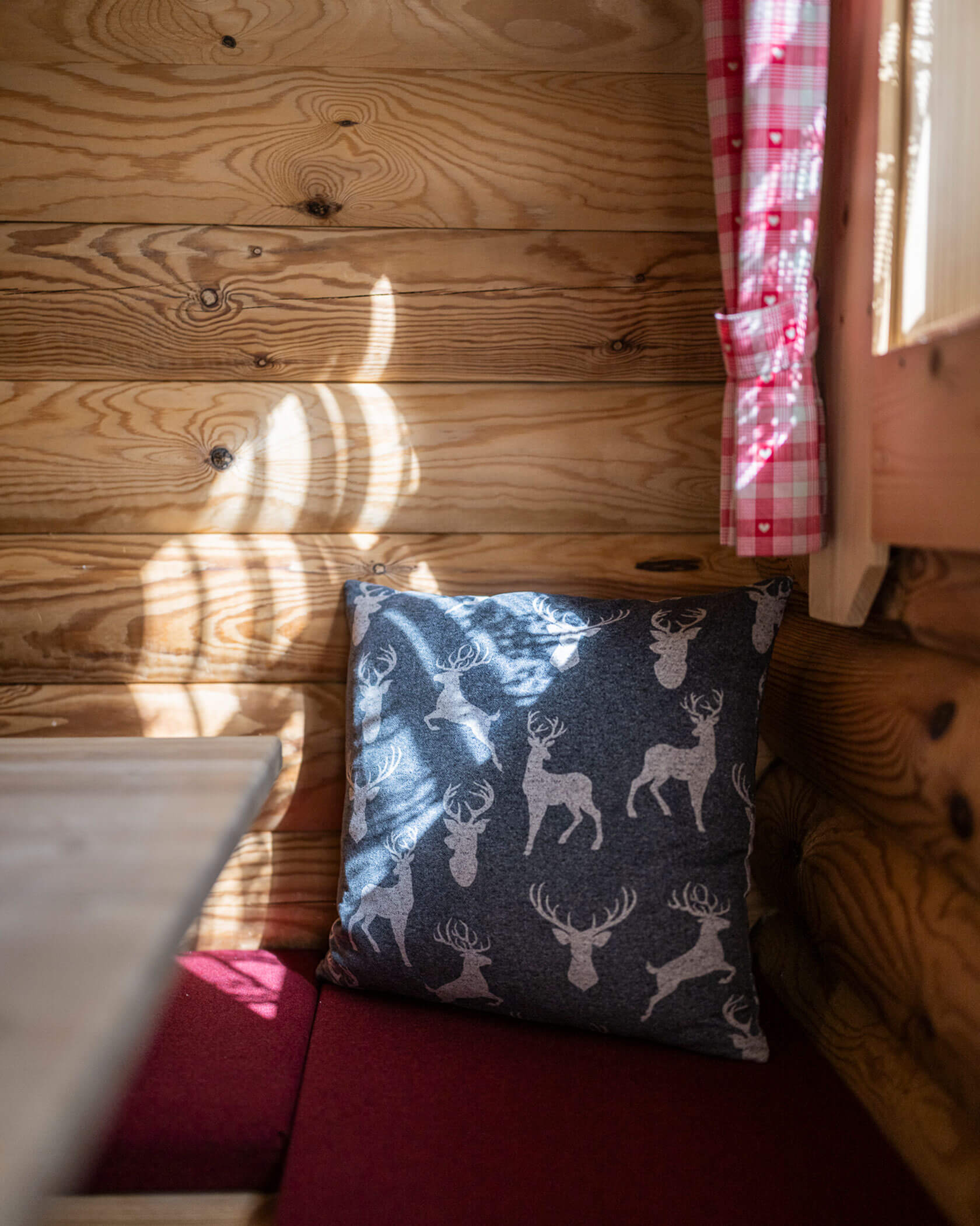 Eckbank mit einem blauem Kissen mit Hirschen darauf - Hotel Anewandter