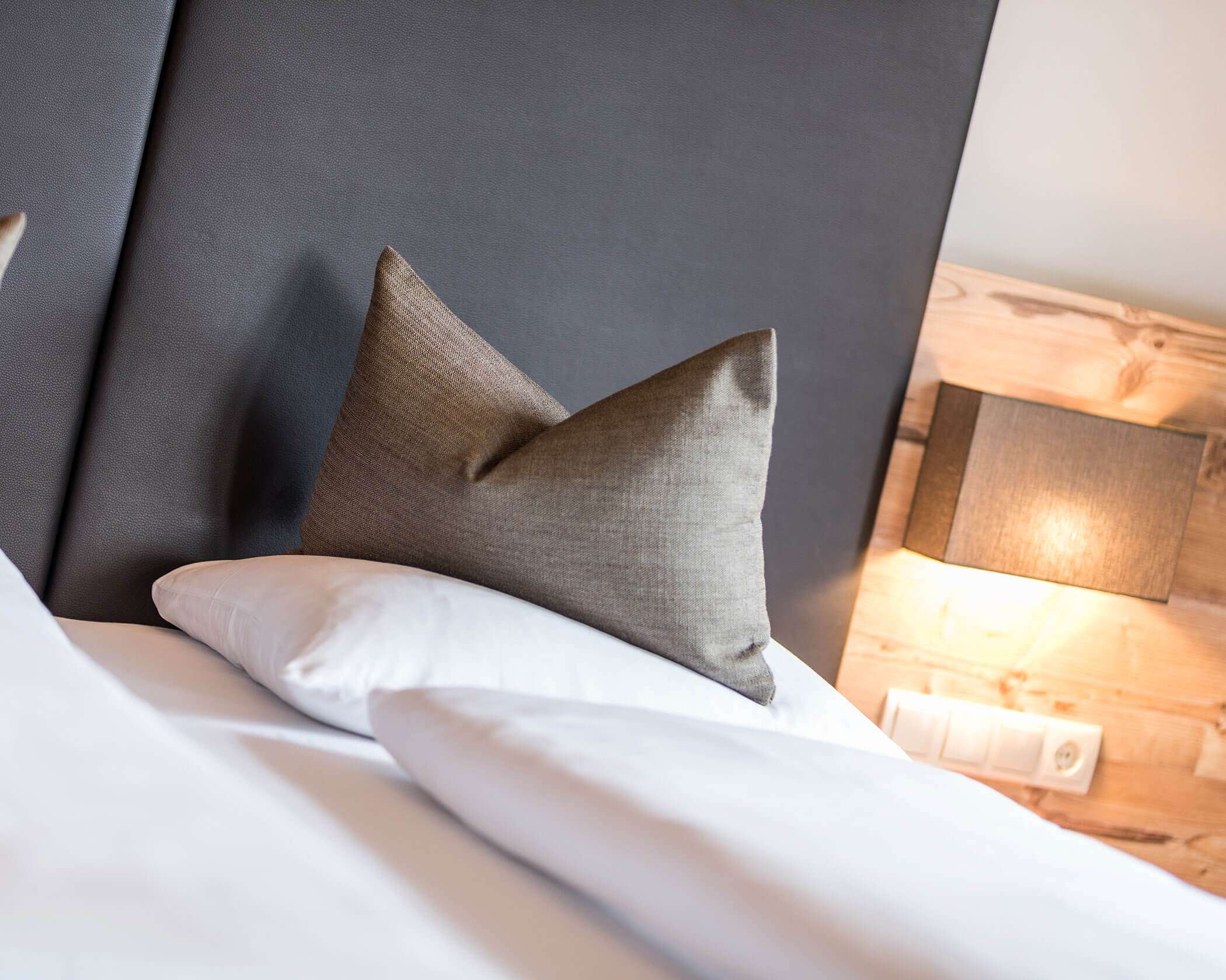 Schlafzimmer mit Doppelbett und beleuchtetem Nachtkästchen - Hotel Anewandter