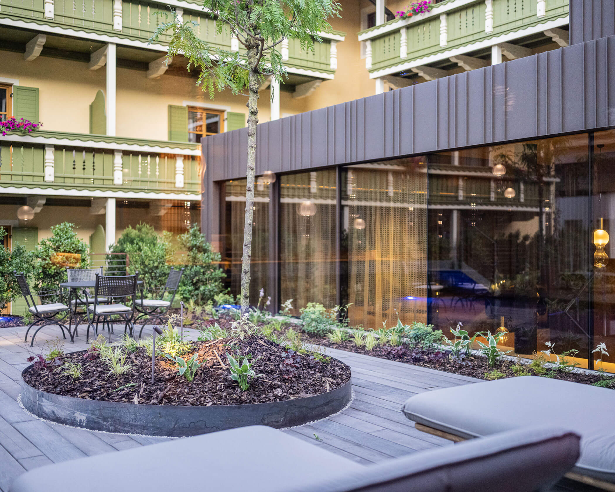 Terrasse mit Liegen und einem Baum im Hotel Anewandter