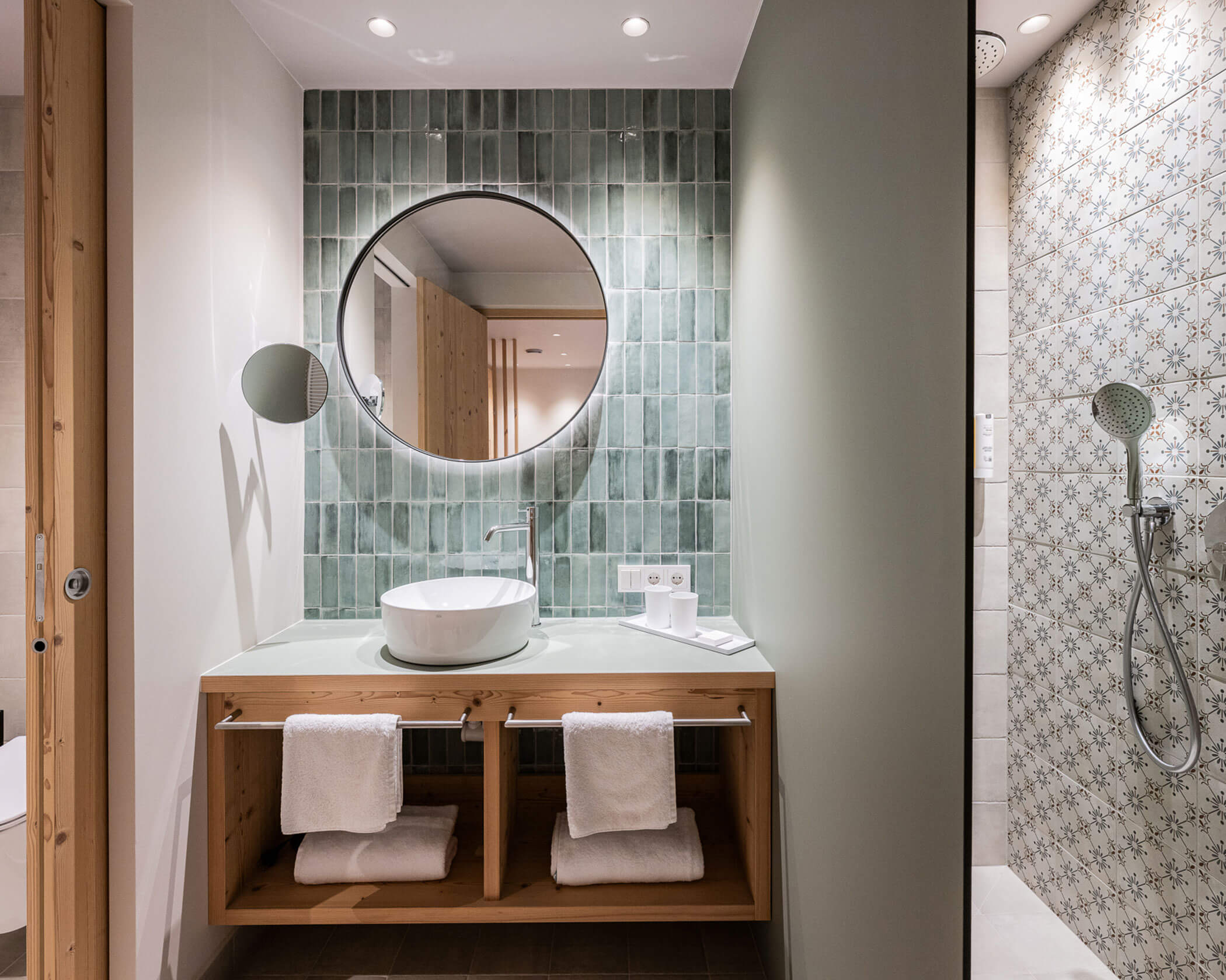 Bagno con specchio rotondo, lavabo e doccia nella camera doppia Garden Superior - Hotel Anewandter