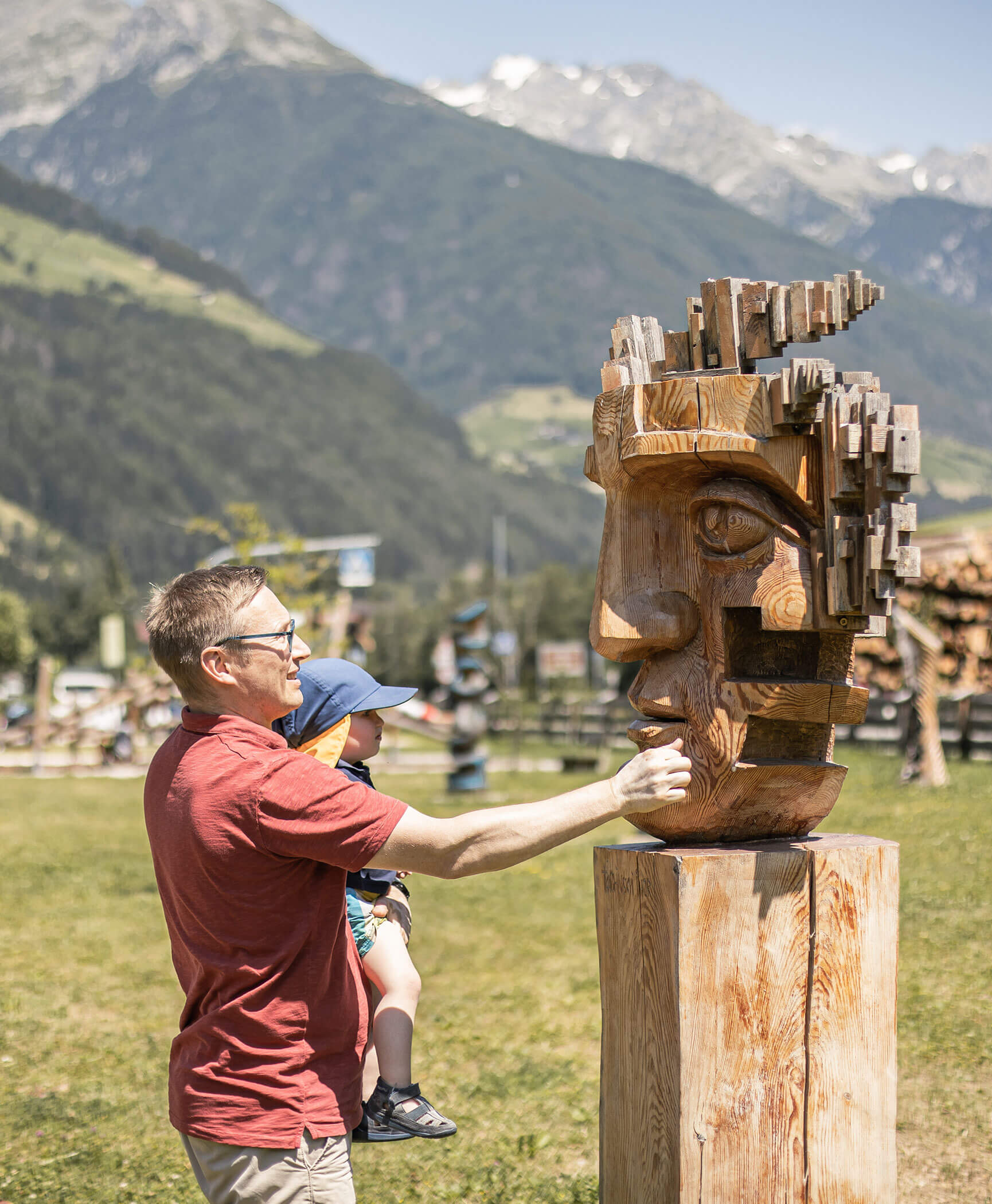 Ein Vater und sein Sohn betrachten eine Holzskulptur - Hotel Anewandter