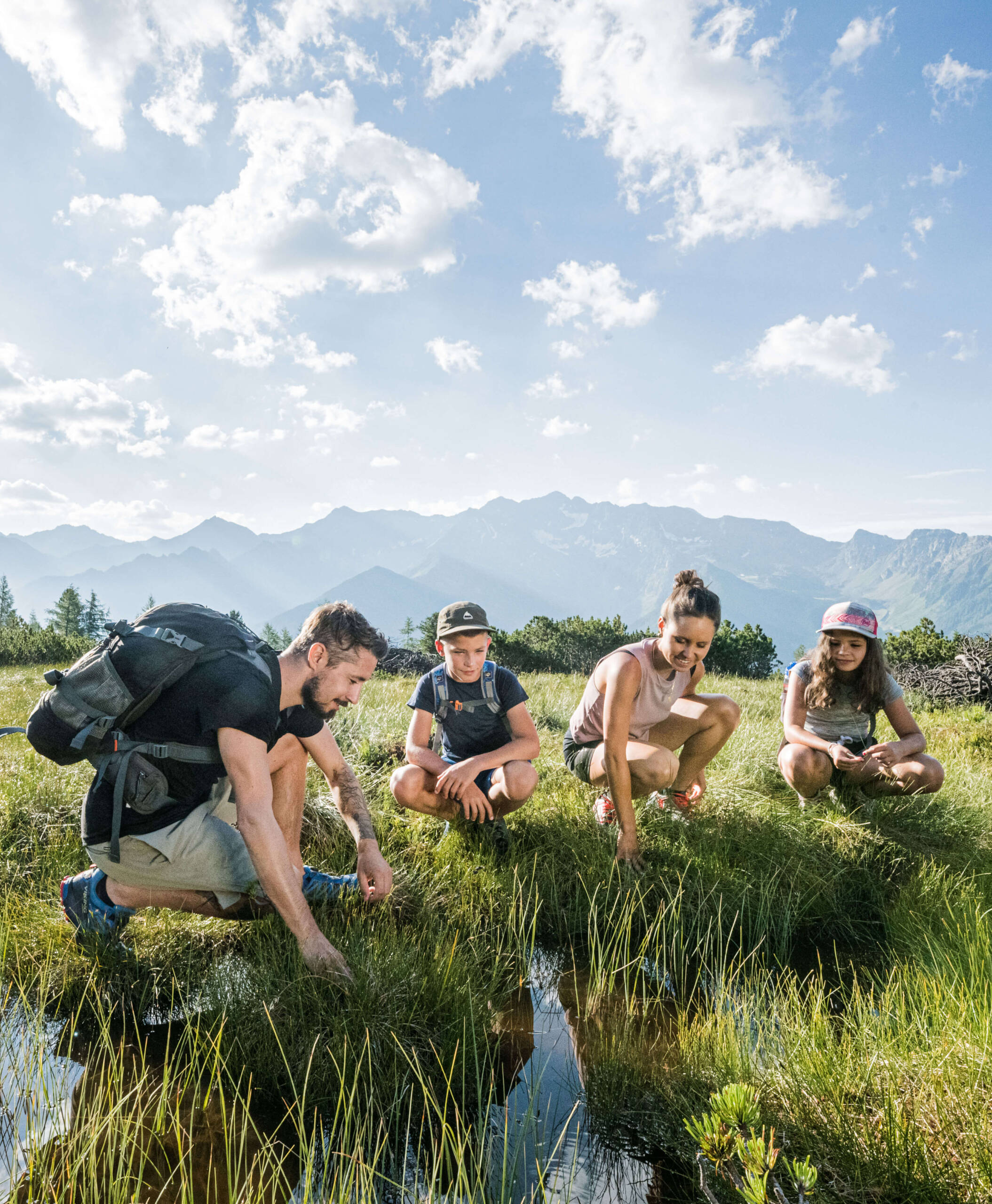 Eine Familie betrachtet den Bach in den Südtiroler Bergen - Hotel Anewandter