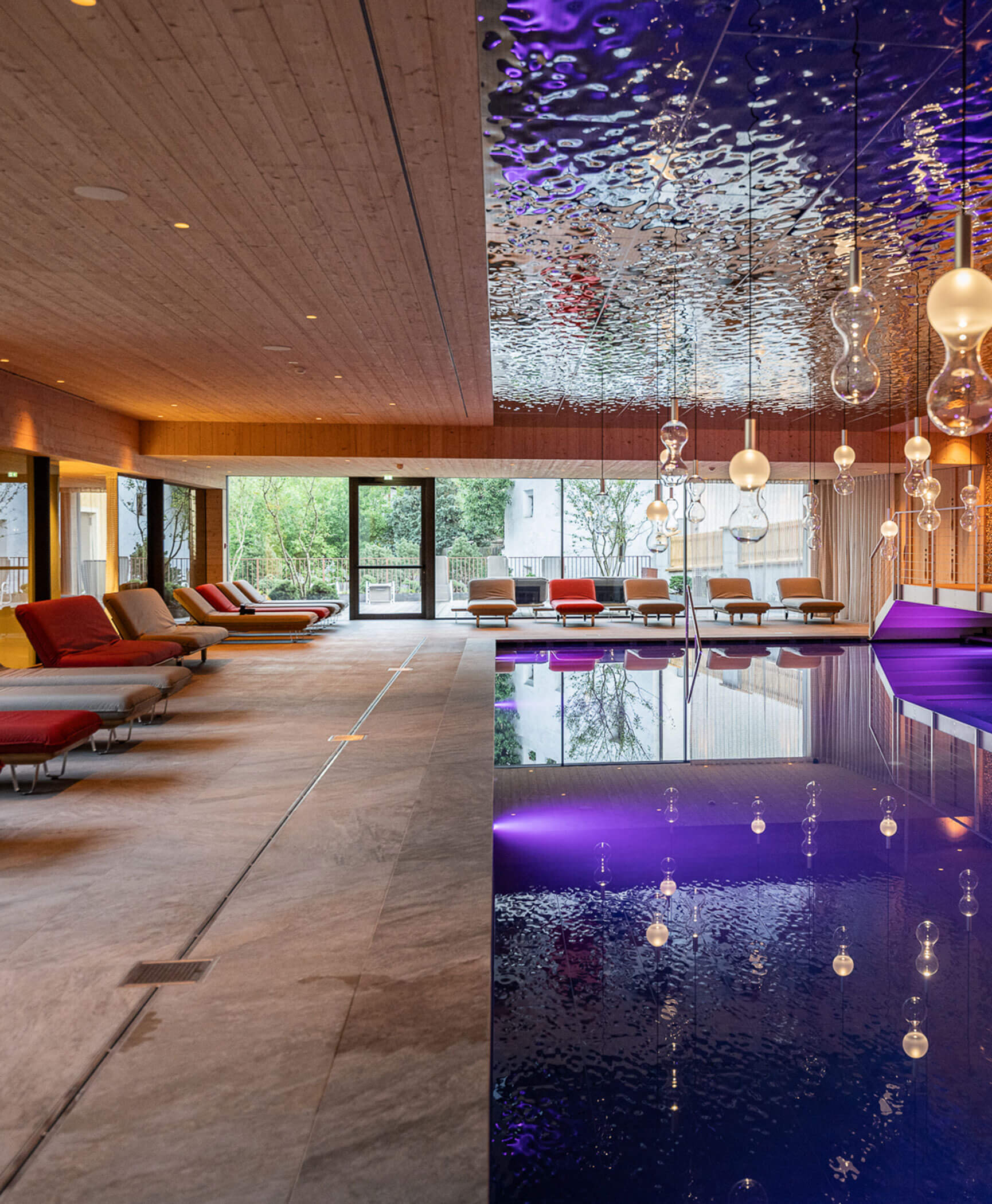 Wellnessbereich mit beleuchteten Pool und Liegestühlen - Hotel Anewandter