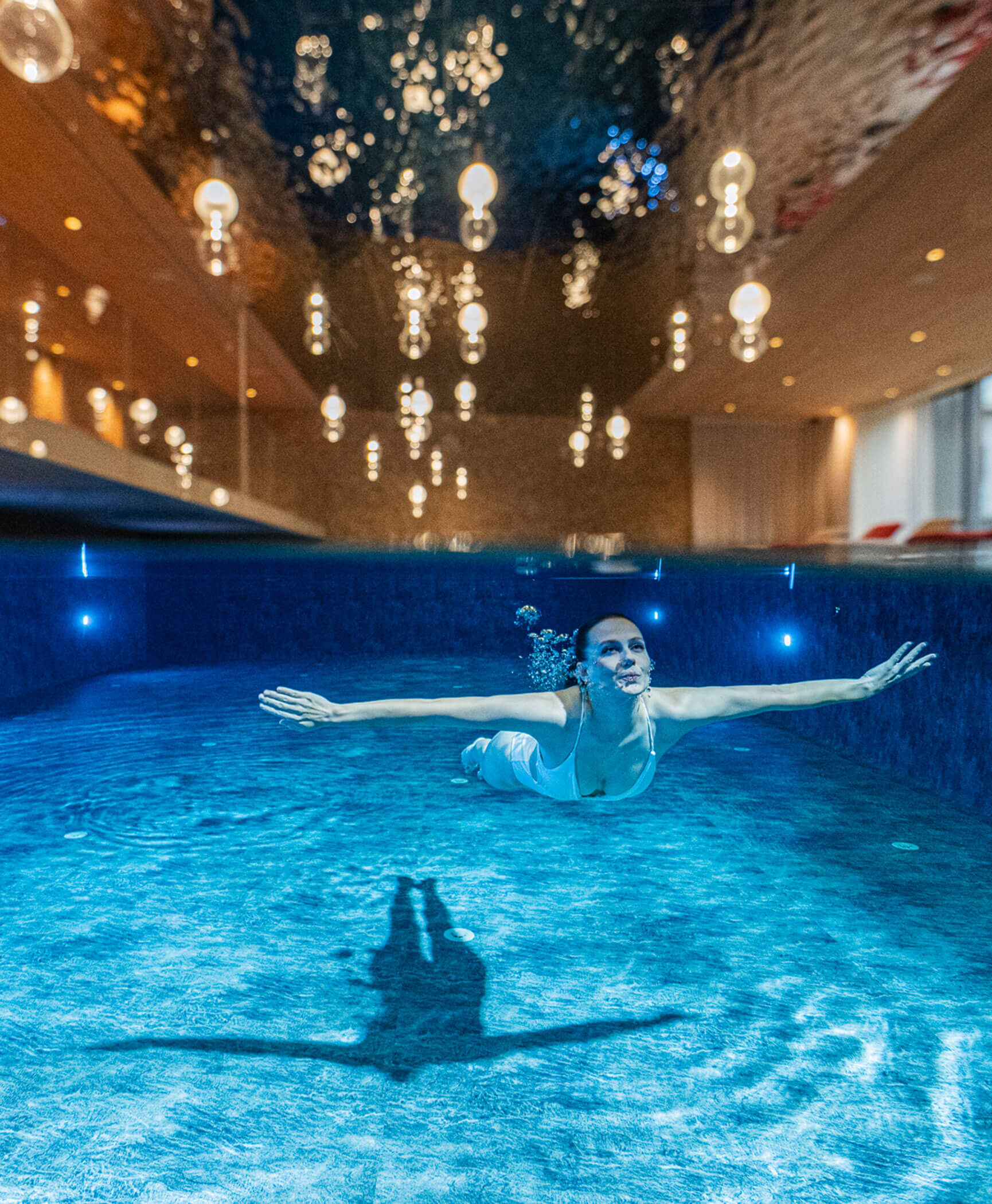 Donna che si immerge nella piscina interna - Hotel Anewandter