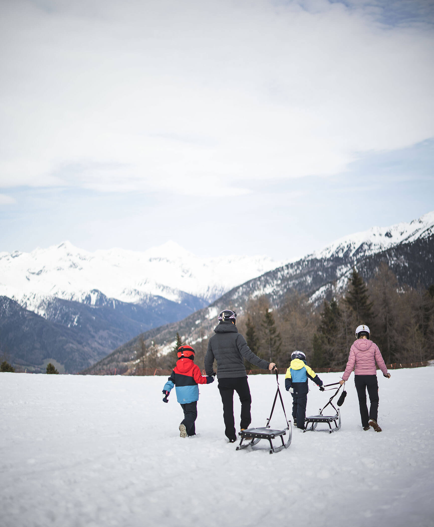Eine Familie ziehen eine Rodel auf der Rodelbahn am Speikboden - Hotel Anewandter