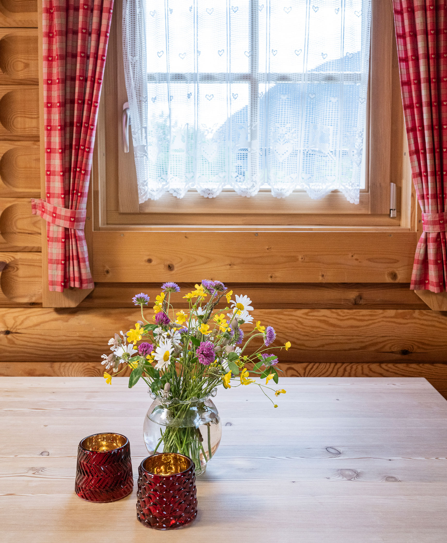 Blumen und Kerzen auf dem Tisch im Blockhaus - Hotel Anewandter