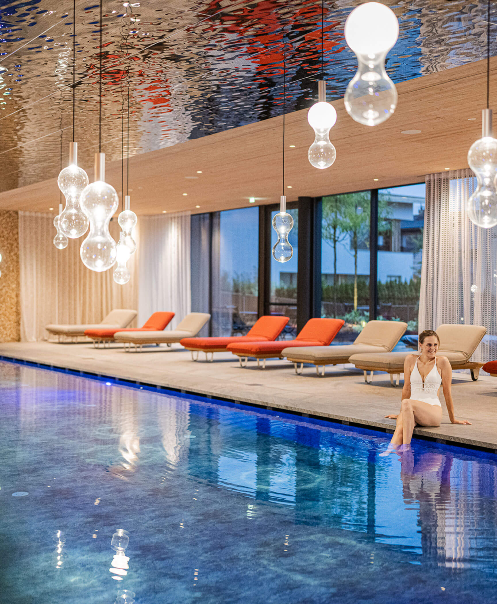 Frau hebt ihre Füße in den Pool - Hotel Anewandter