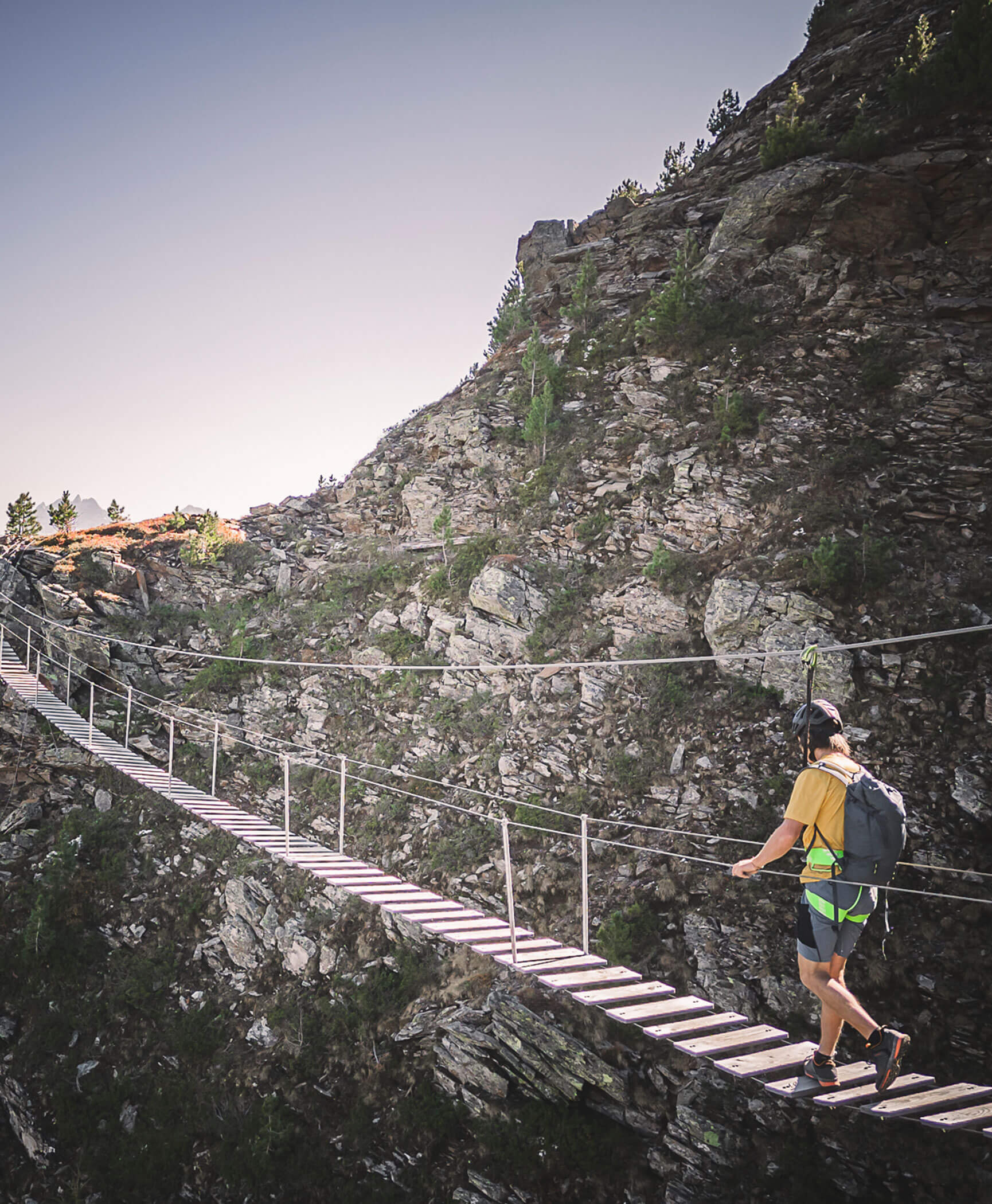 A man crossing the bridge of a via ferrata - Hotel Anewandter