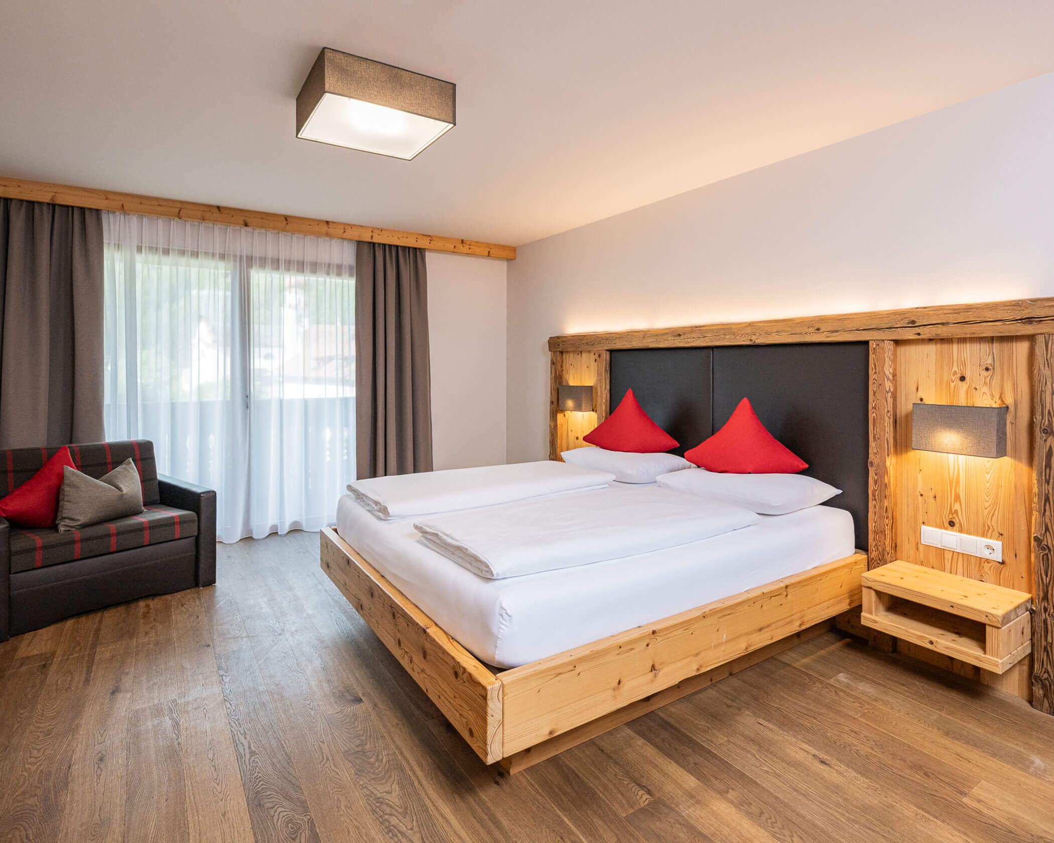 Camera da letto con letto matrimoniale e divano nella suite Anewandter - Hotel Anewandter