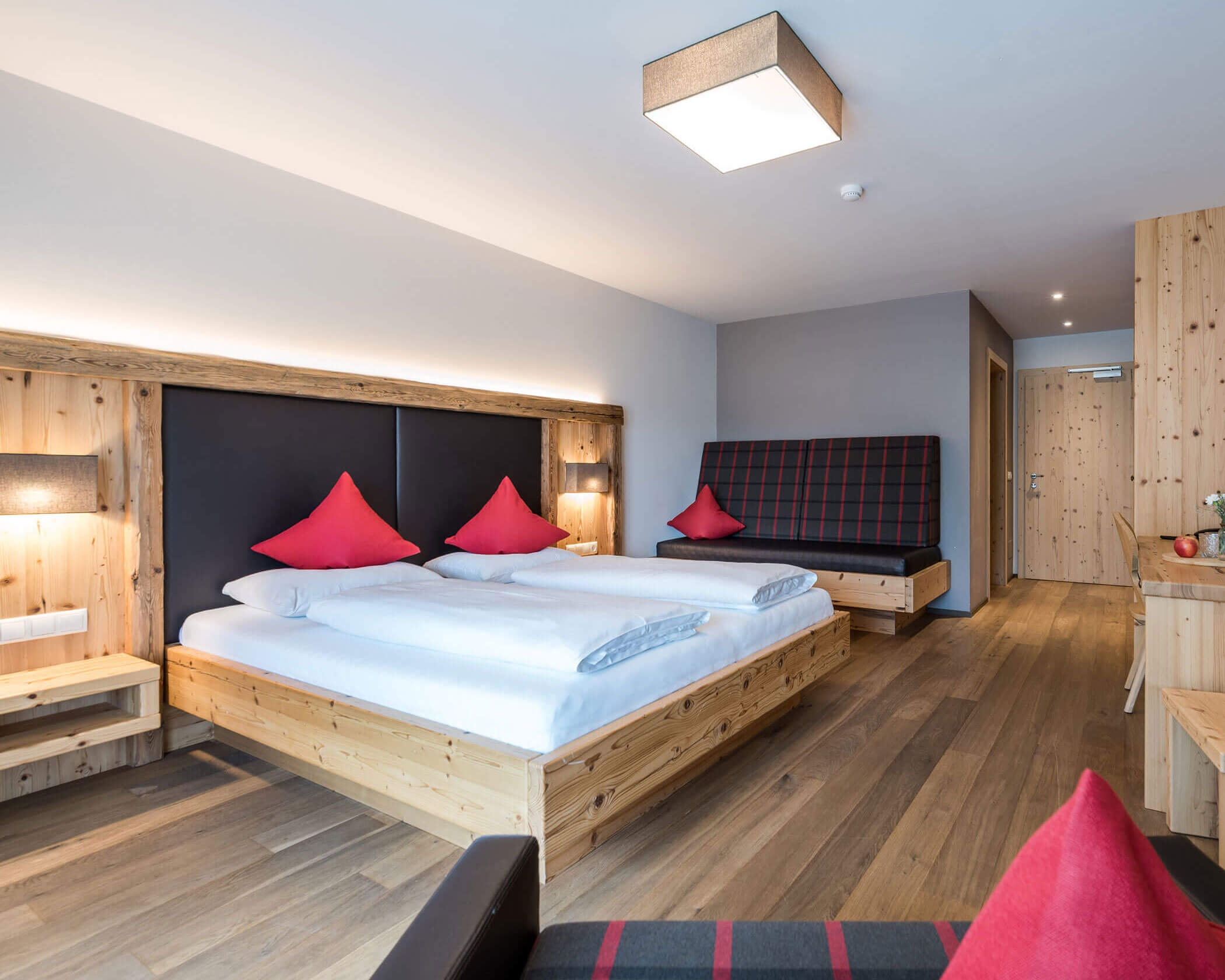 Schlafzimmer mit Doppelbett und einem Sofa daneben in einer Suite - Hotel Anewandter