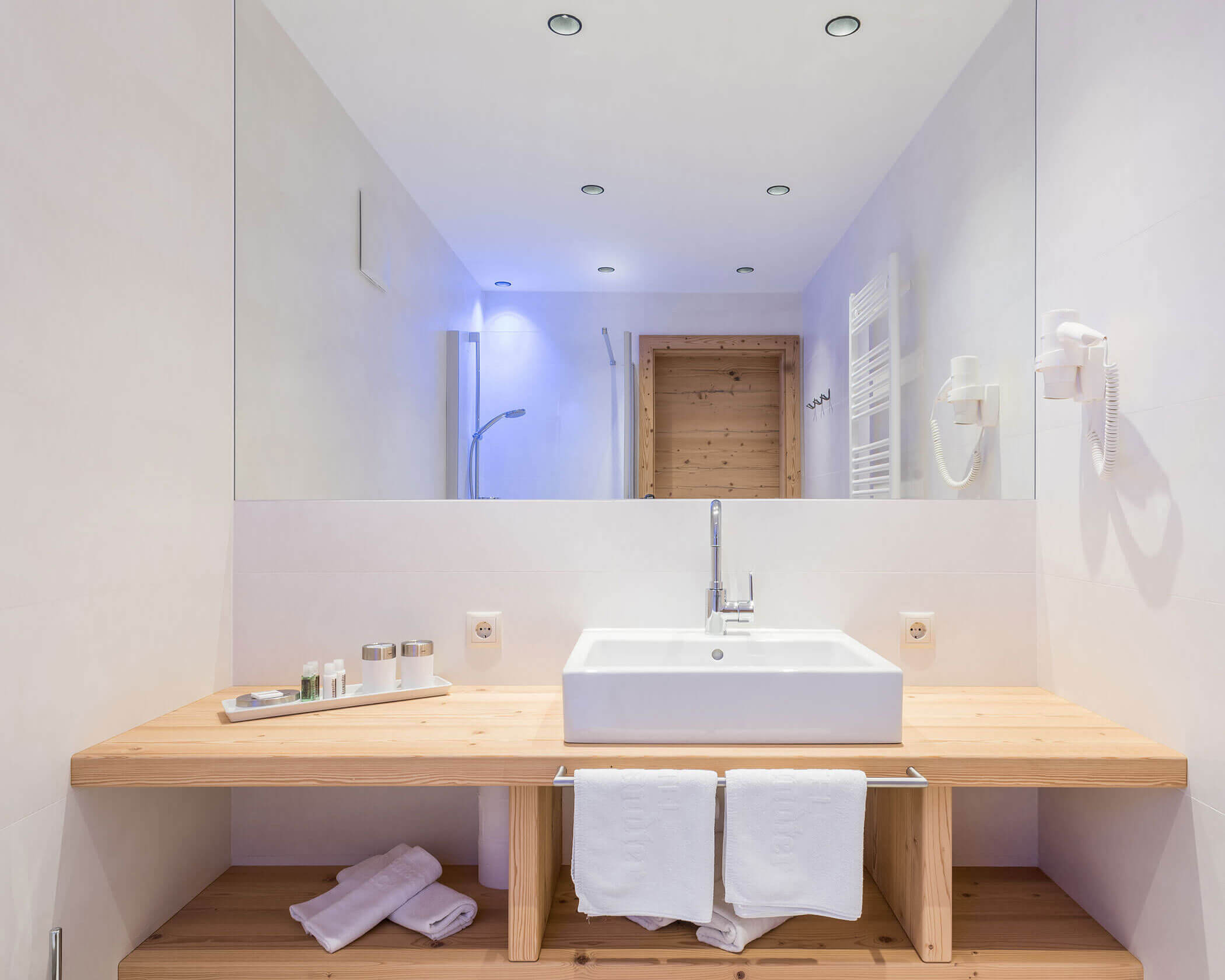 Bagno con grande specchio e lavabo nell'Hotel Anewandter