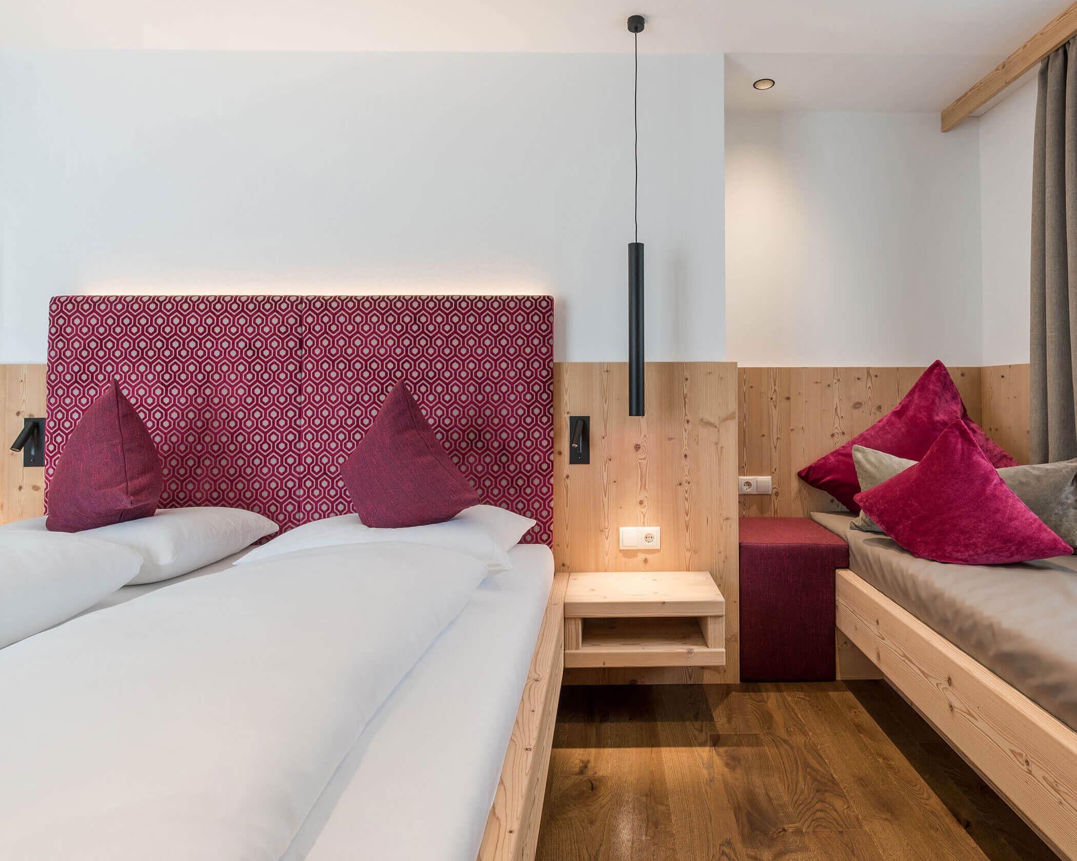 Letto matrimoniale con schienale rosso e un divano accanto - Hotel Anewandter