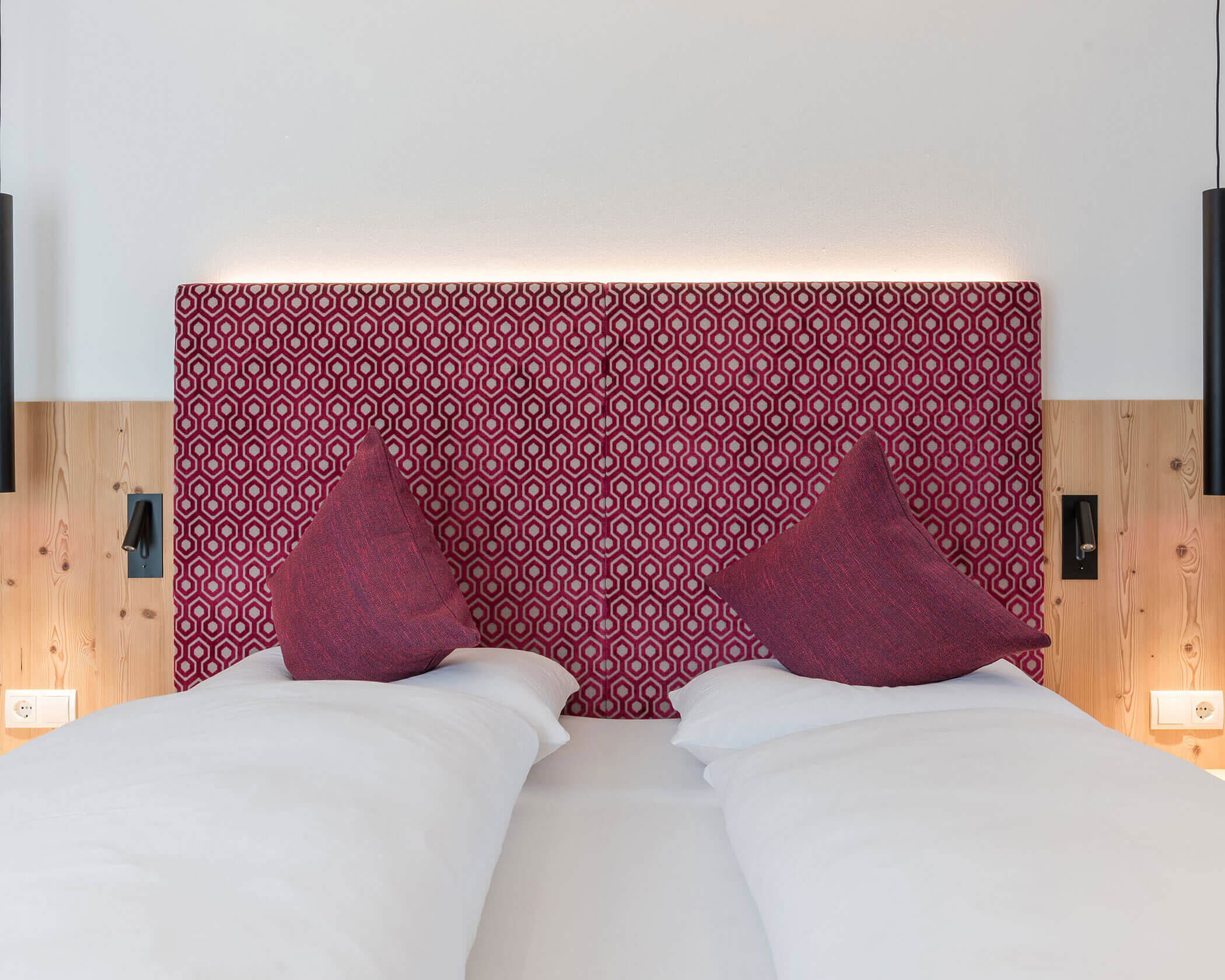 Letto matrimoniale con schienale rosso e cuscini rossi - Hotel Anewandter