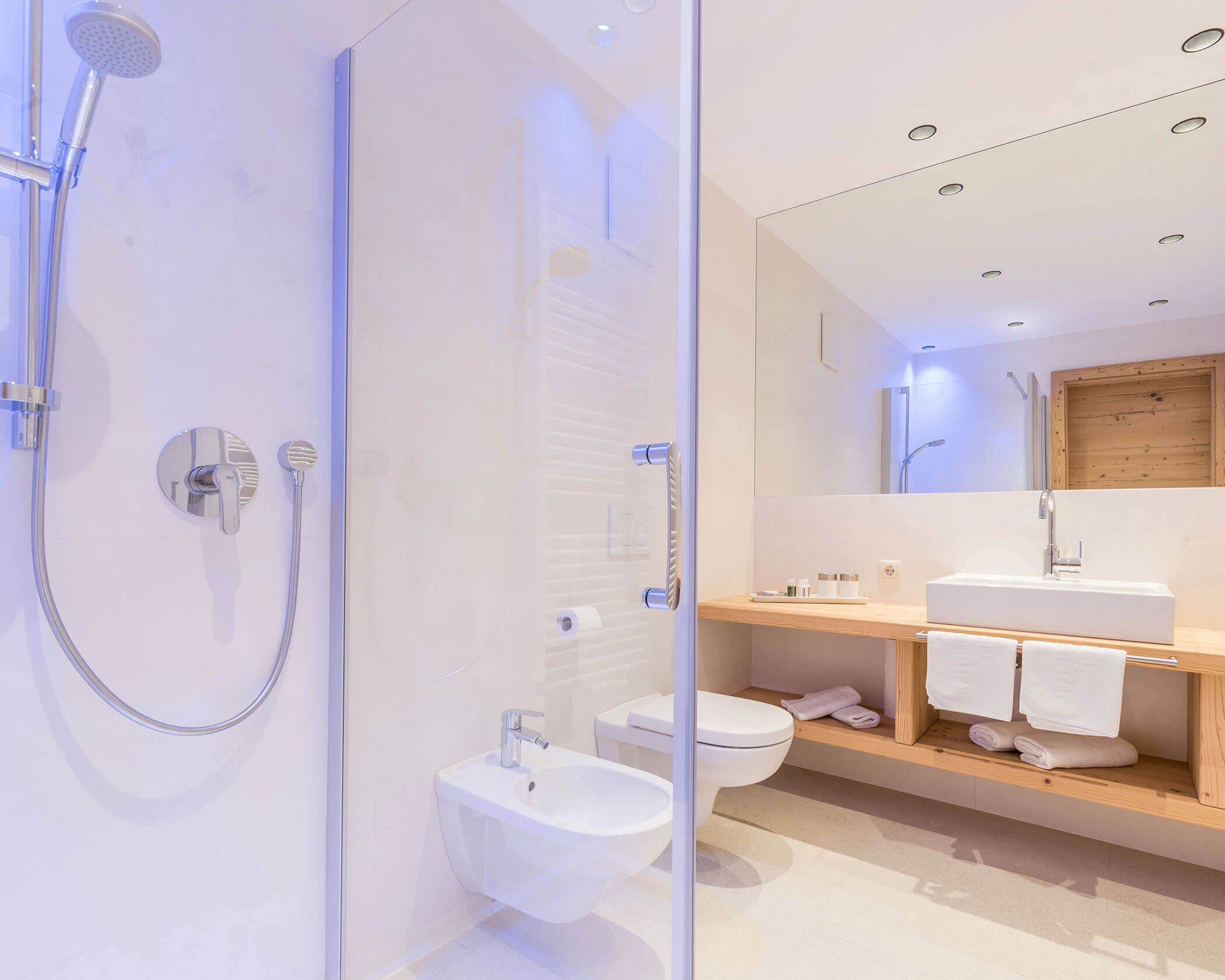 Bagno con WC, bidet, doccia, grande specchio e lavandino in una suite - Hotel Anewandter
