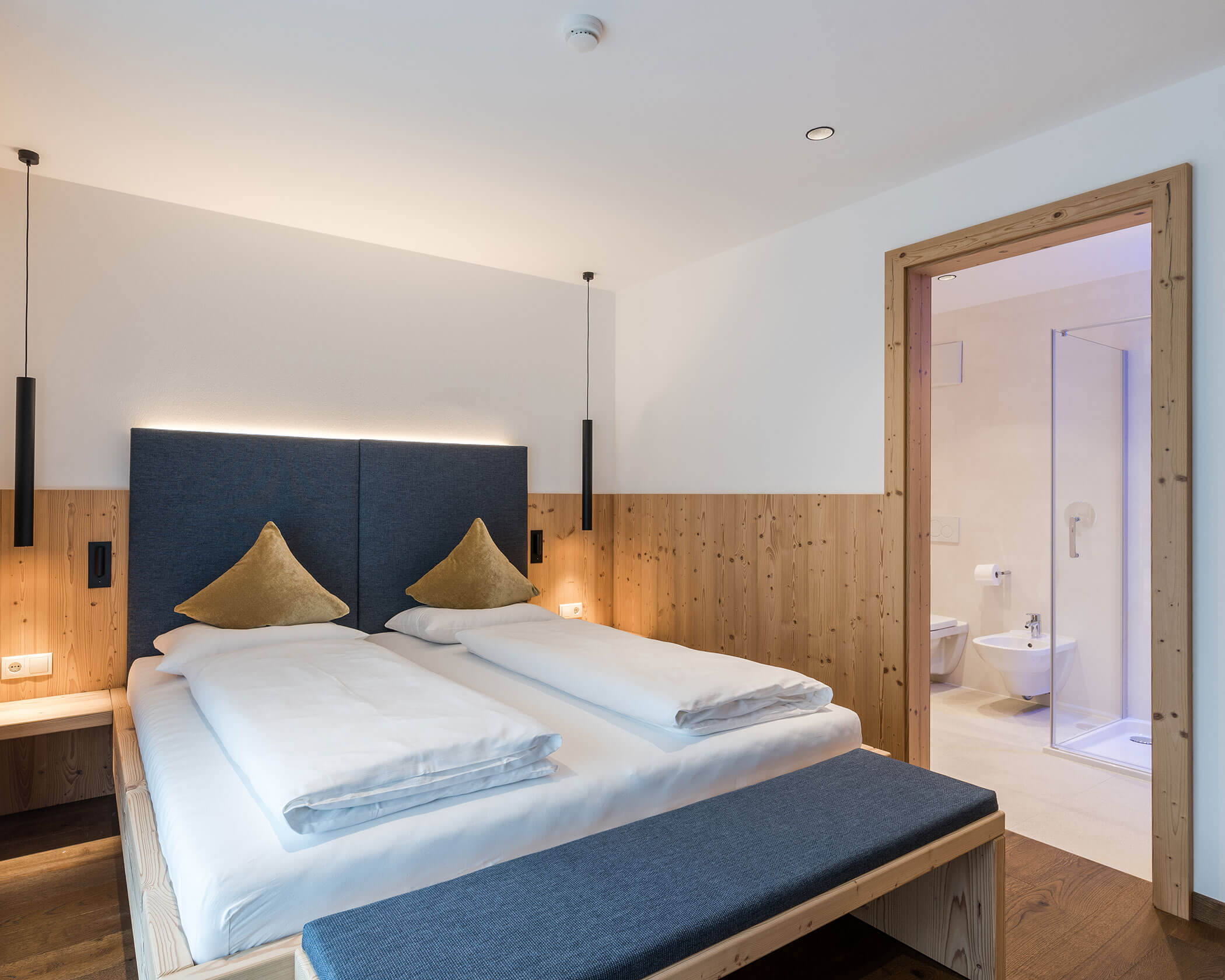 Doppelbett mit Holzbank davor im Doppelzimmer Superior - Hotel Anewandter