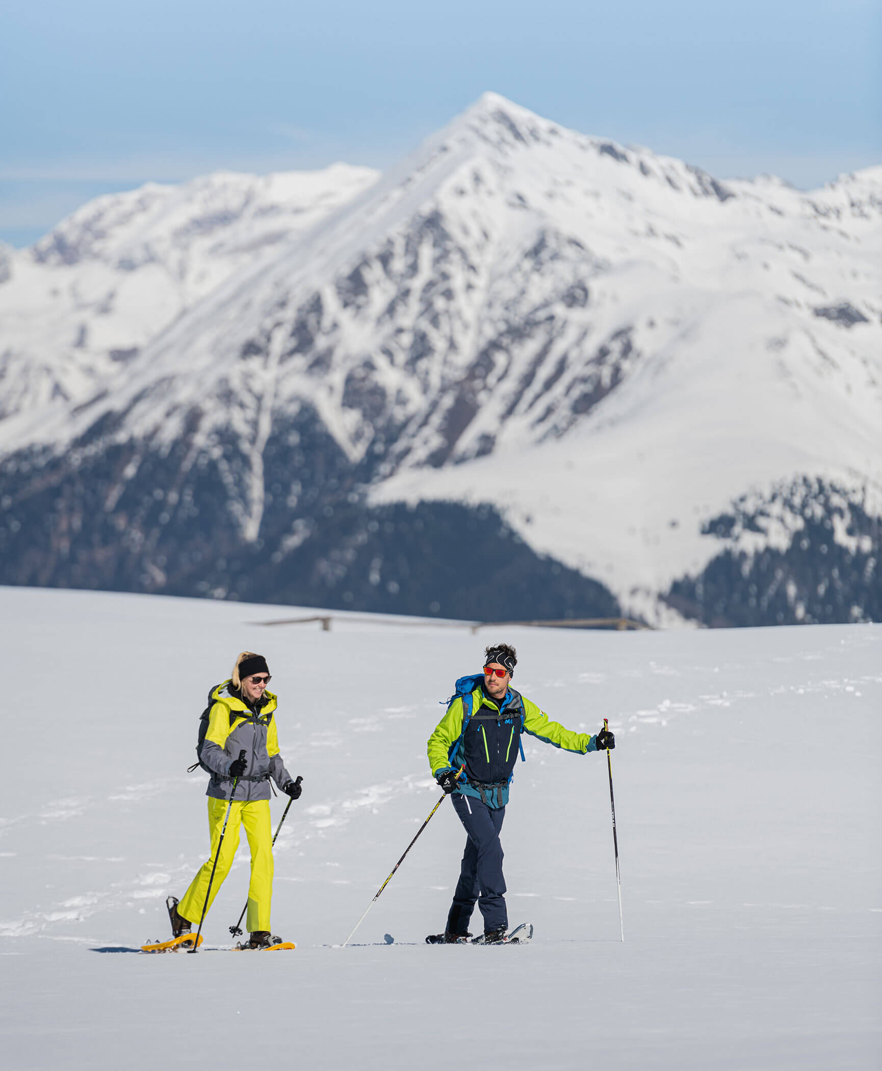 Due escursionisti con le ciaspole in un paesaggio innevato con le montagne dell'Alto Adige sullo sfondo - Hotel Anewandter